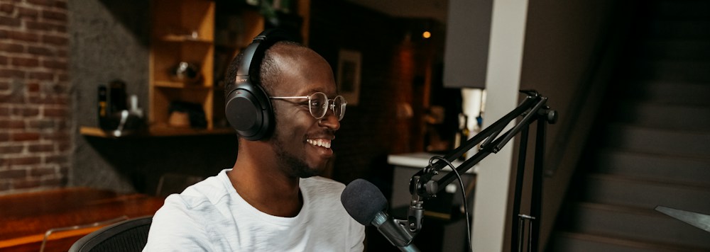 A creator recording a conversation with headphones and a studio microphone